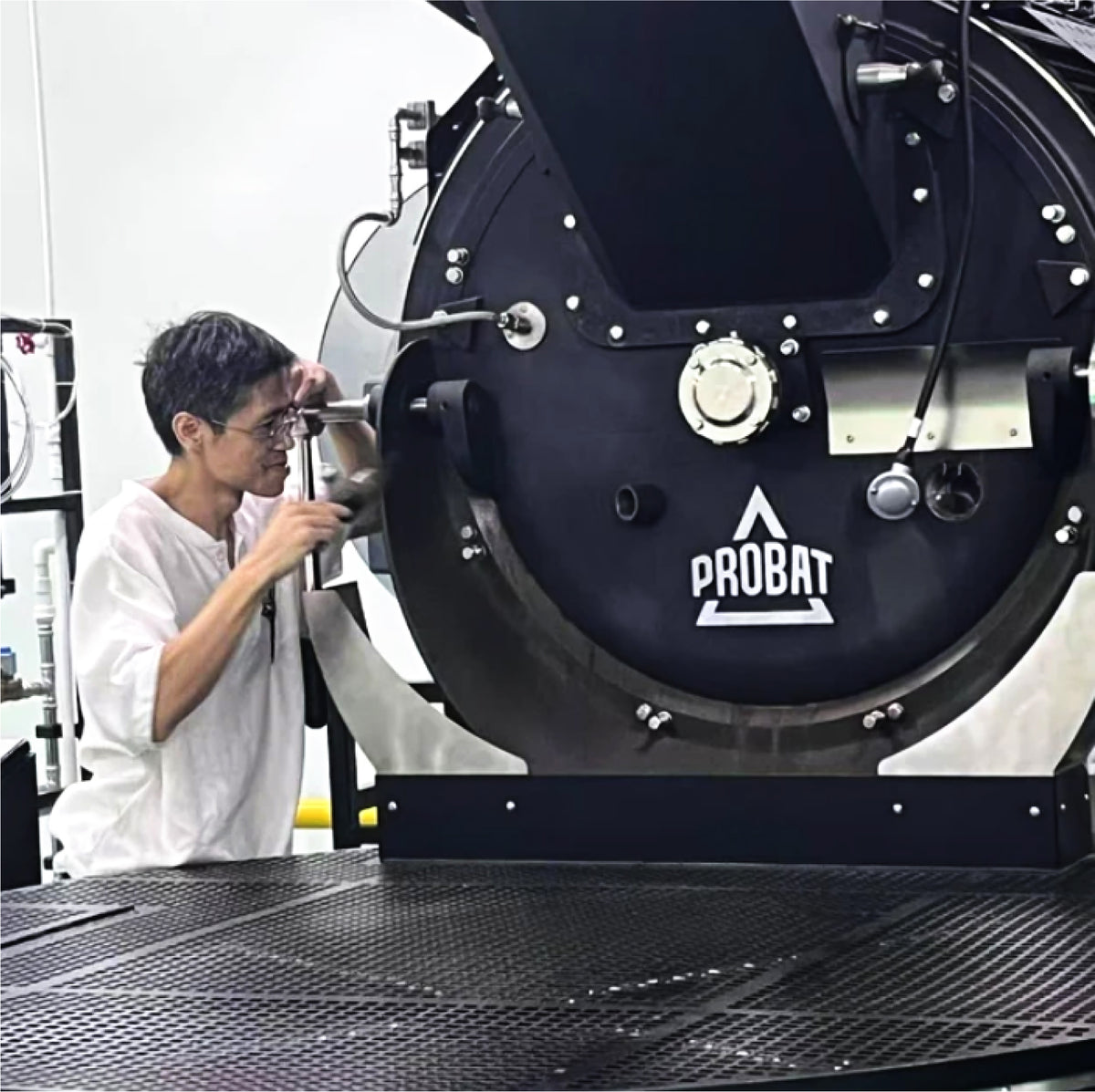 Roastmaster checking a Probat coffee roaster during production